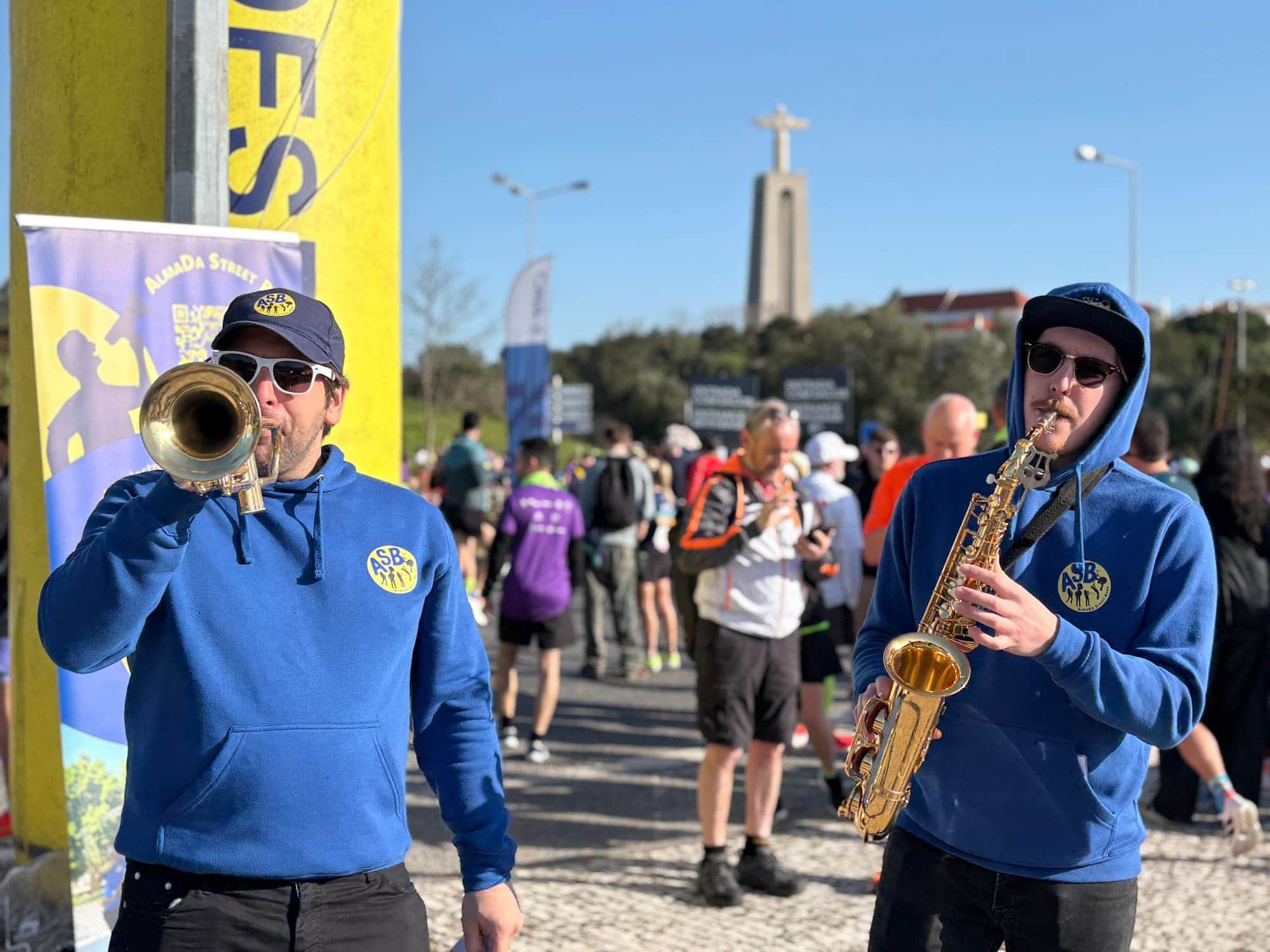 Trompete e saxofone a tocar no meio dos corredores, com o Cristo Rei ao fundo