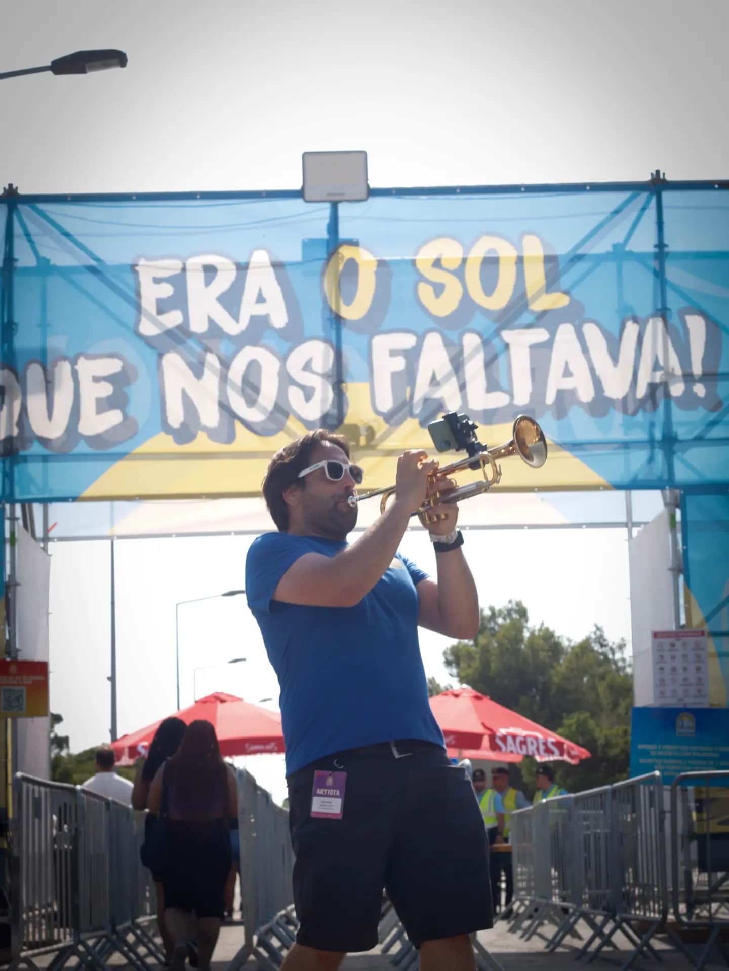Trompetista de capuz azul a tocar junto à bandeira da ASB